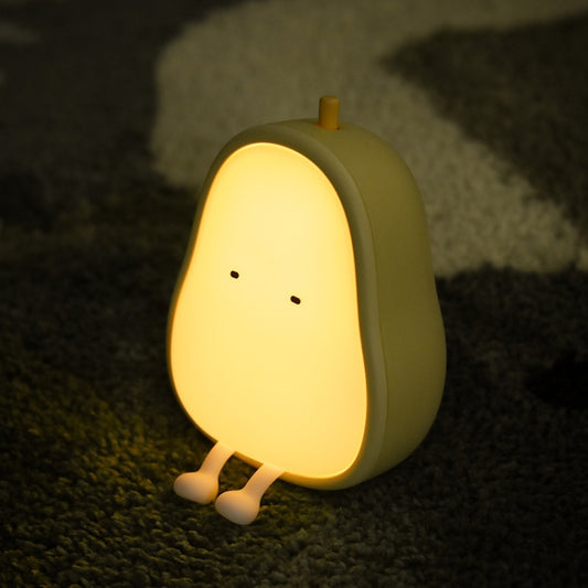 Warm LED pear-shaped night light with glowing white face and silicone body, standing upright.