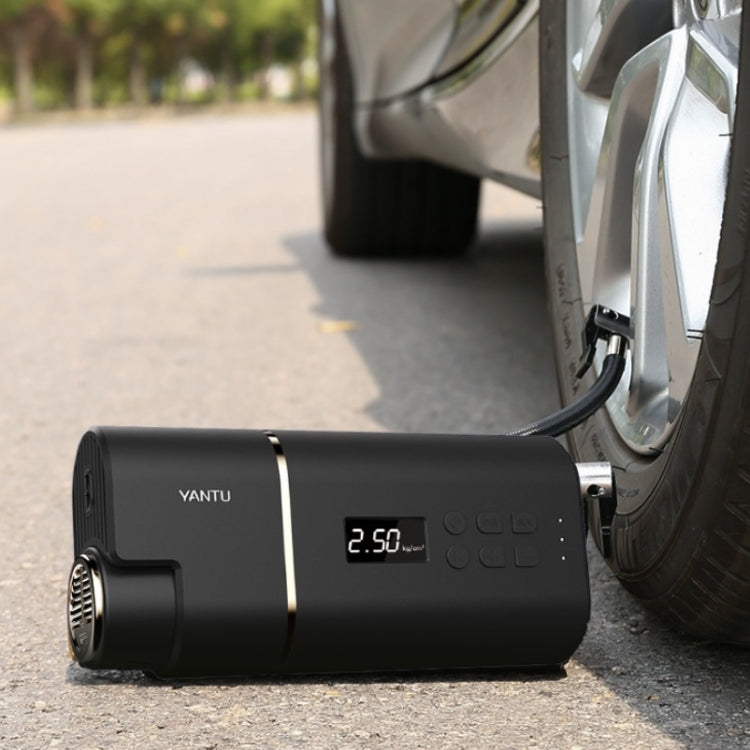 YANTU black portable tire inflator connected to a car tire valve on the road