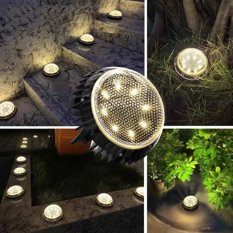 Warm white solar LED ground lights glowing, clear domes with black spikes