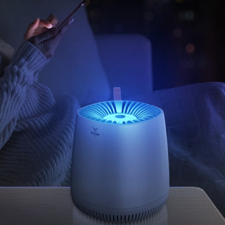 White indoor mosquito killer lamp glowing blue on a bedside table