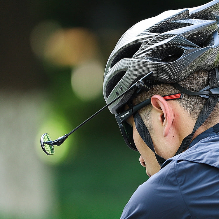 Cyclist wearing road bike helmet with attached convex rearview mirror