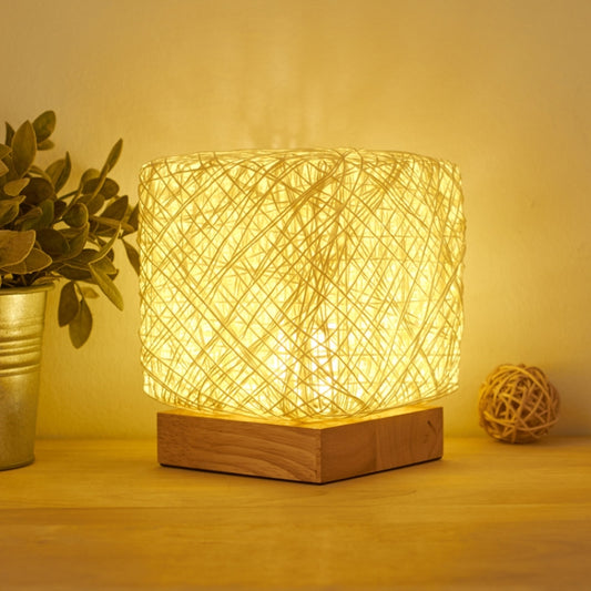 Square woven rattan table lamp with warm beige light and wood base