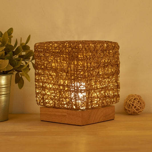 Square woven rattan table lamp with amber light glow and wood base