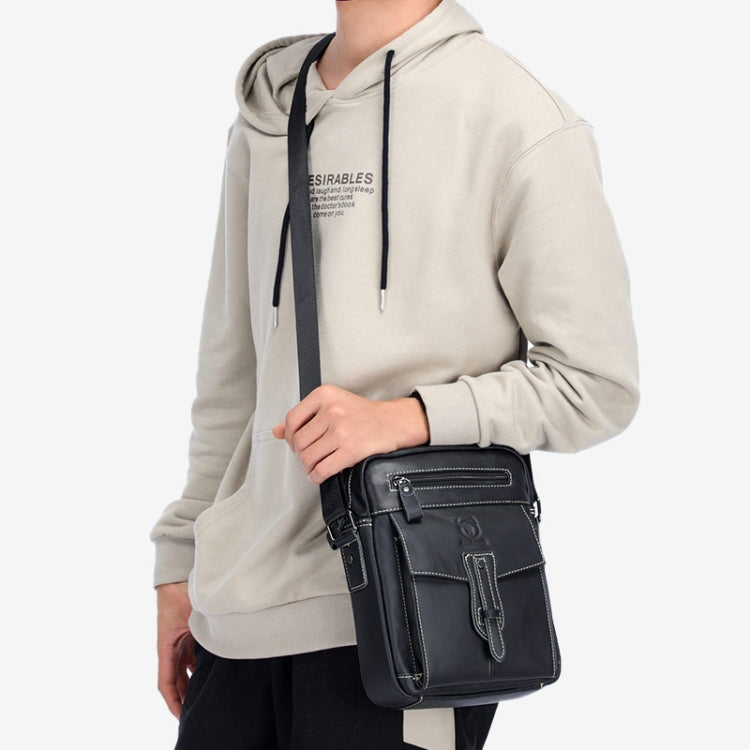 Black leather shoulder messenger bag worn crossbody with front flap and zip pockets