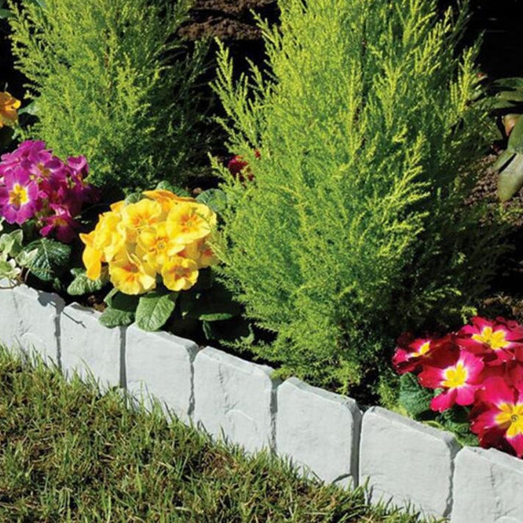 Gray imitation stone garden fence edging segments along a lawn border
