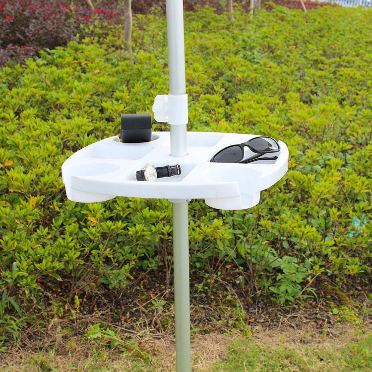 White umbrella cup holder tray mounted on pole outdoors with cups and accessories