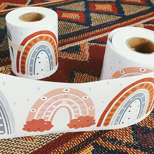 Rainbow border sticker roll with printed arches and clouds on a white backing