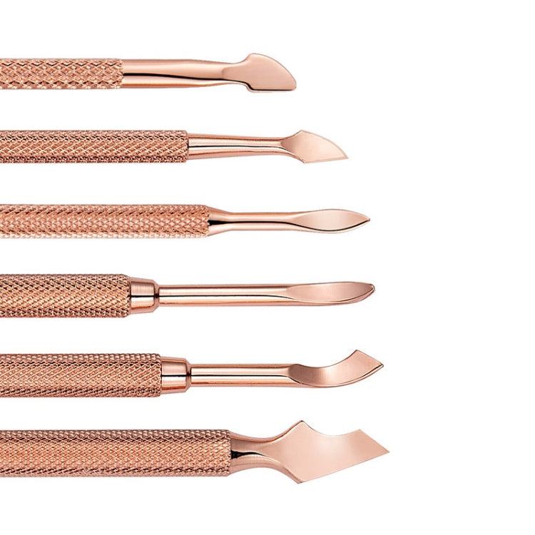 Close-up of rose-gold nail push tools with pointed curved tips and textured handles.