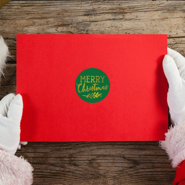 Red gift envelope with green round “Merry Christmas” sticker label