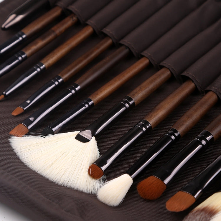 Row of makeup brushes with brown handles and black ferrules arranged in a dark case