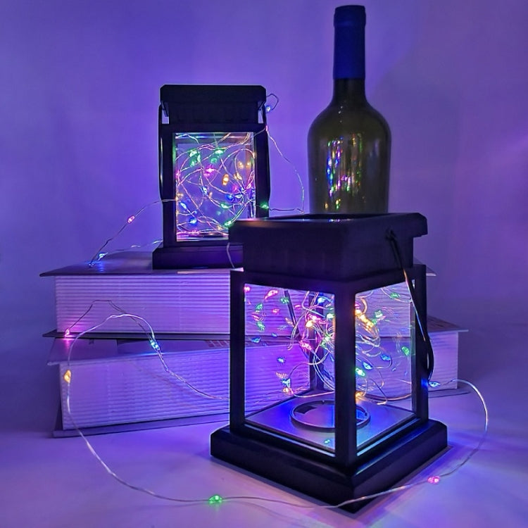Solar LED wind lantern glowing with multicolor wire lights; black base and wire strand