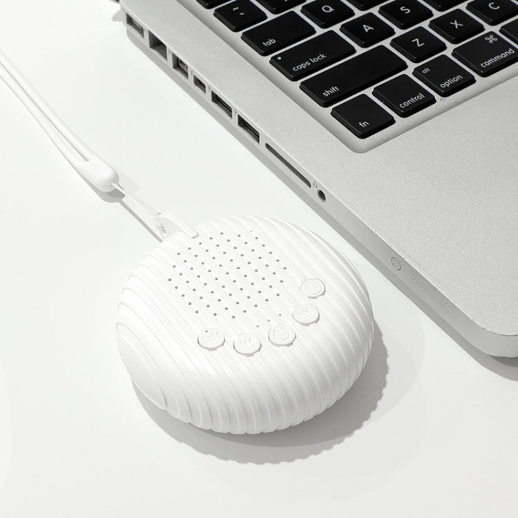 White round baby sleep sound machine connected to a USB port by cable