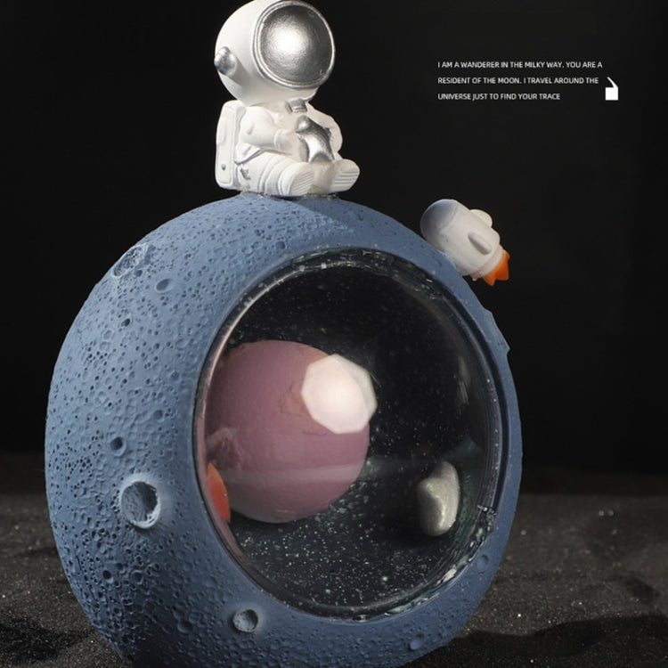 Blue planet astronaut night light with silver astronaut figure and glowing interior orb