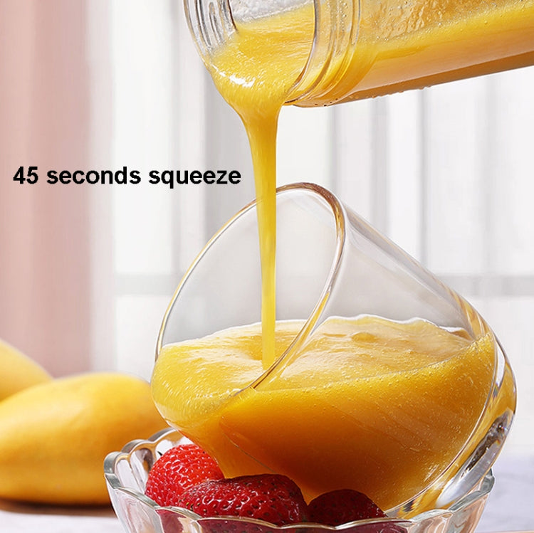 Yellow juice poured from the electric juicer into a clear cup with fruit