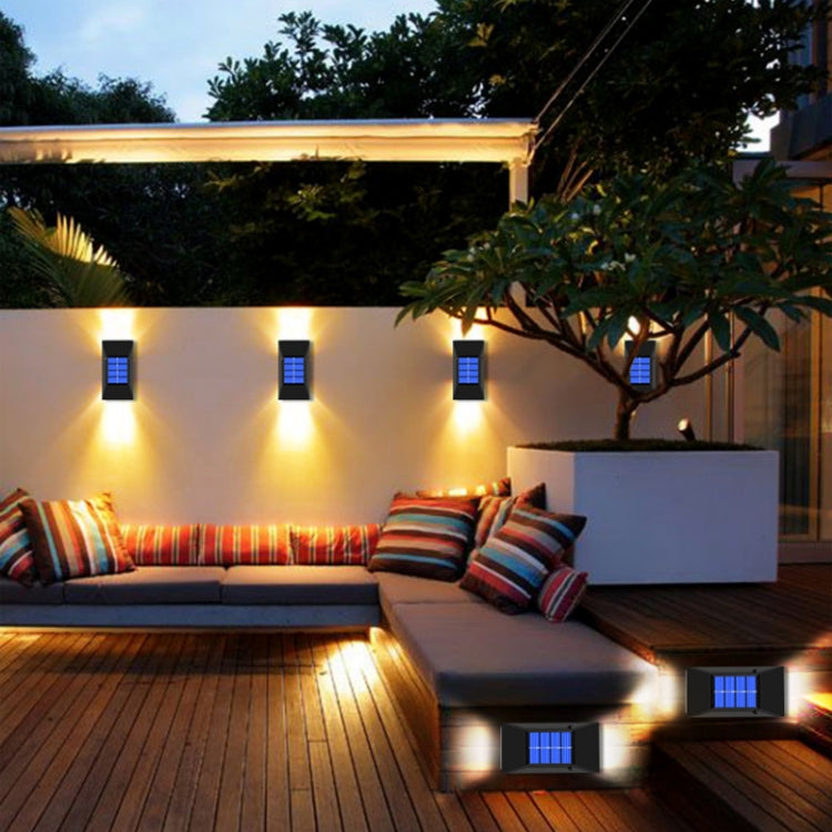 Outdoor patio with multiple black solar wall lights glowing blue LED panels