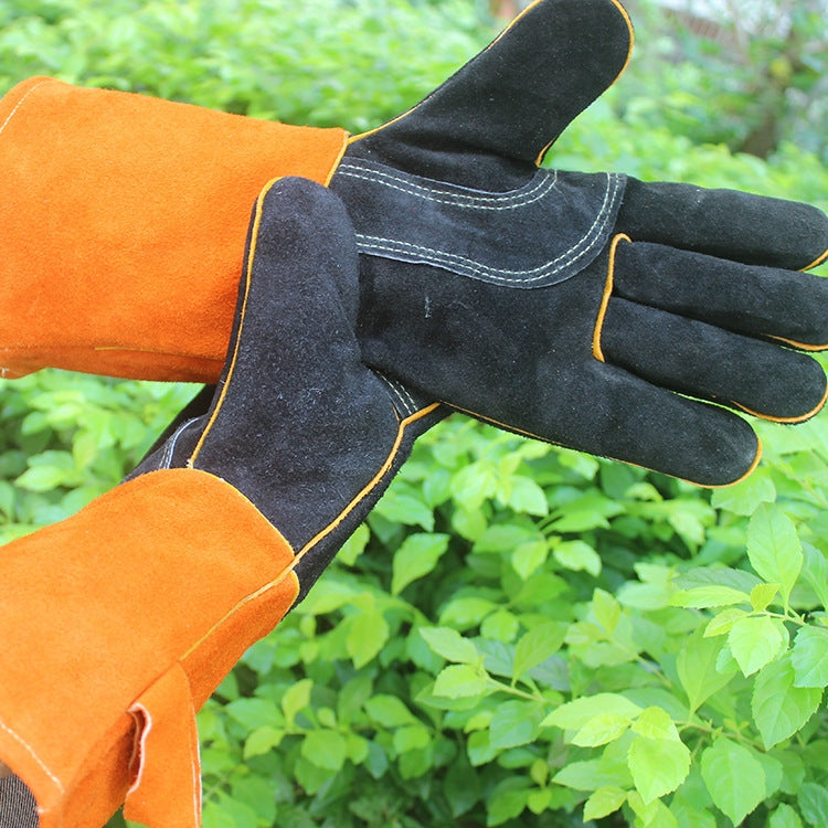Orange-and-black leather welding glove showing thumb seam and knuckle stitching.