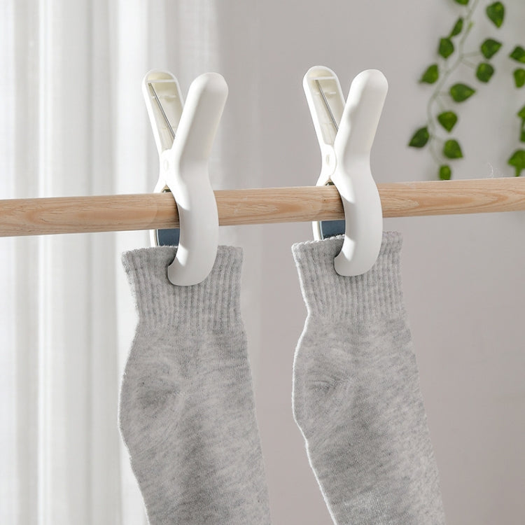 Two plastic windproof clothespin clips on a wooden rod holding gray socks
