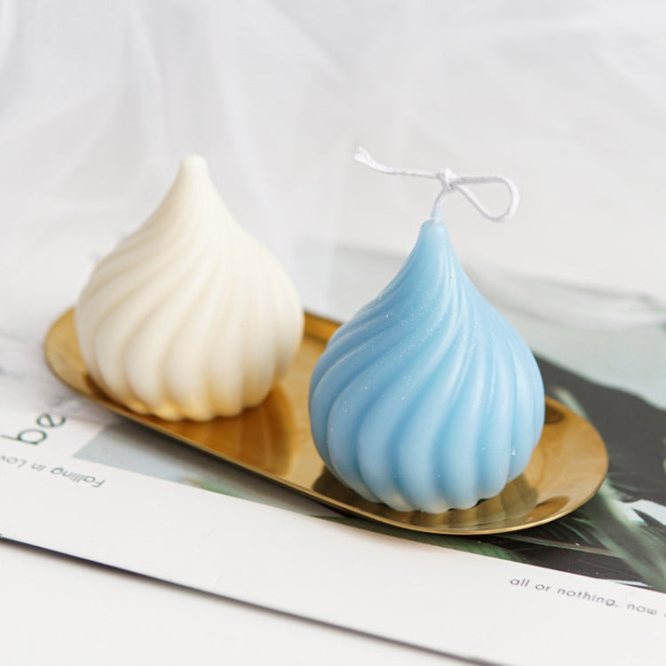 Blue and cream onion-shaped candles on tray beside ridged onion candle mold
