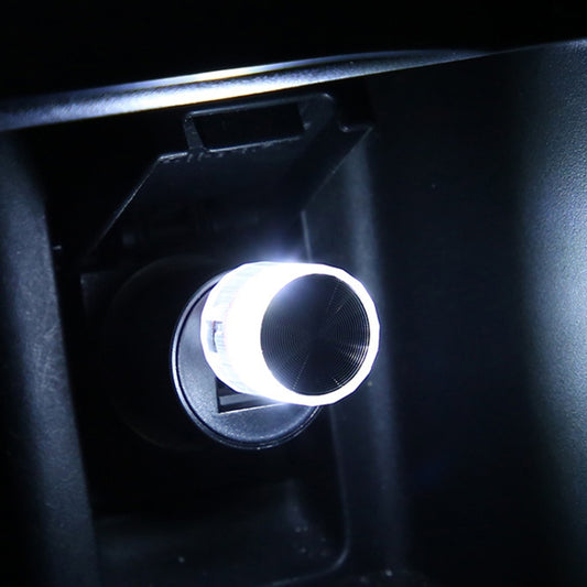 Car USB LED atmosphere lamp in round housing, lit white on car console panel