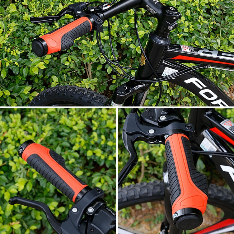Orange and black anti-slip grips installed on a bicycle handlebar.