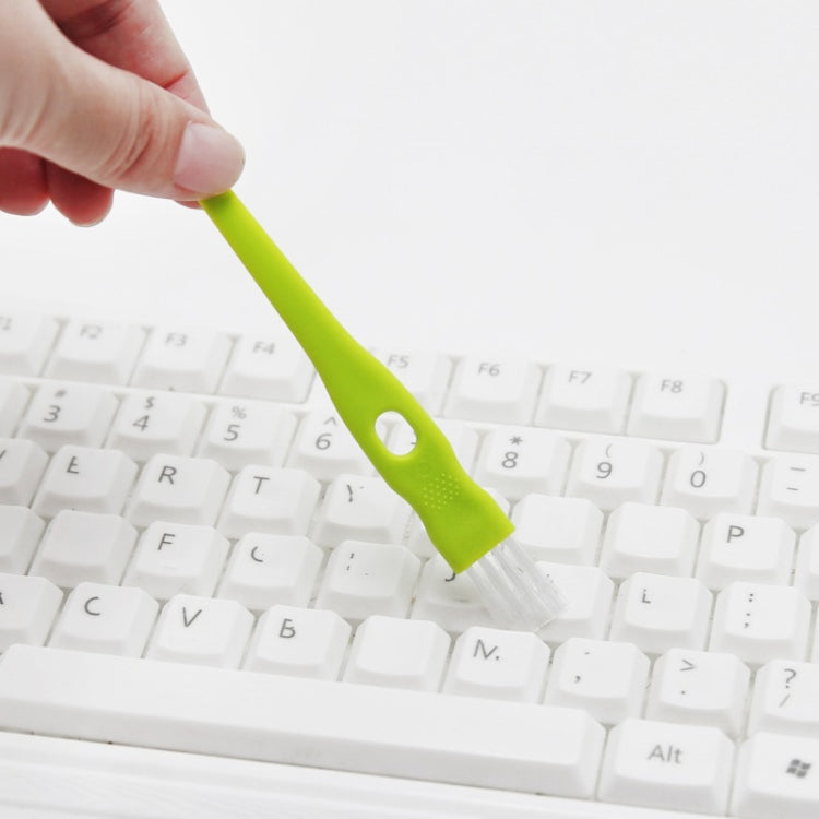 Green crevice cleaning brush for cleaning keyboard keys and tight spaces