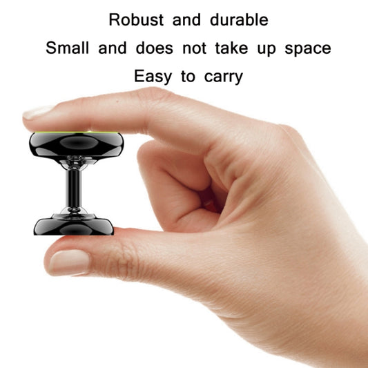 Black compact magnetic phone holder with suction-style base, hand shown
