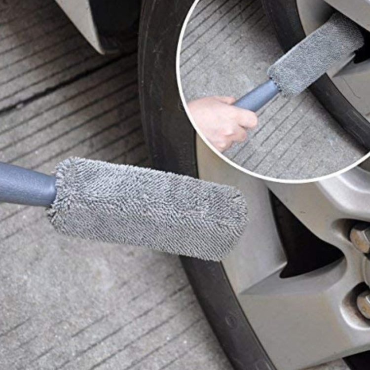 Wheel brush with gray bristles cleaning car rim and tire tread