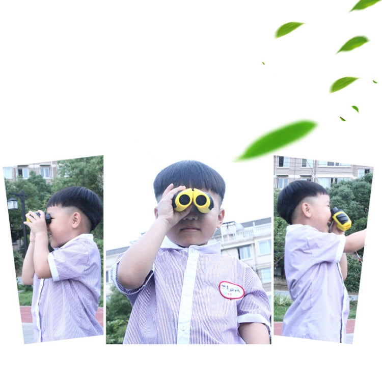 Yellow children’s mini binoculars held up by a child outdoors
