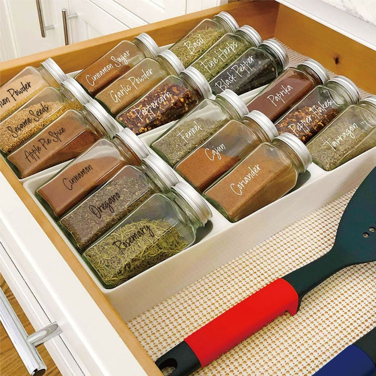 Transparent waterproof spice labels on multiple glass jars in kitchen storage tray