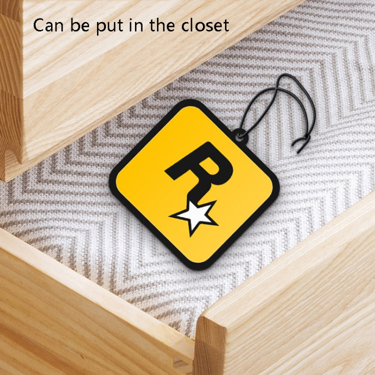 Orange R star fragrance tag resting on a closet shelf with cord