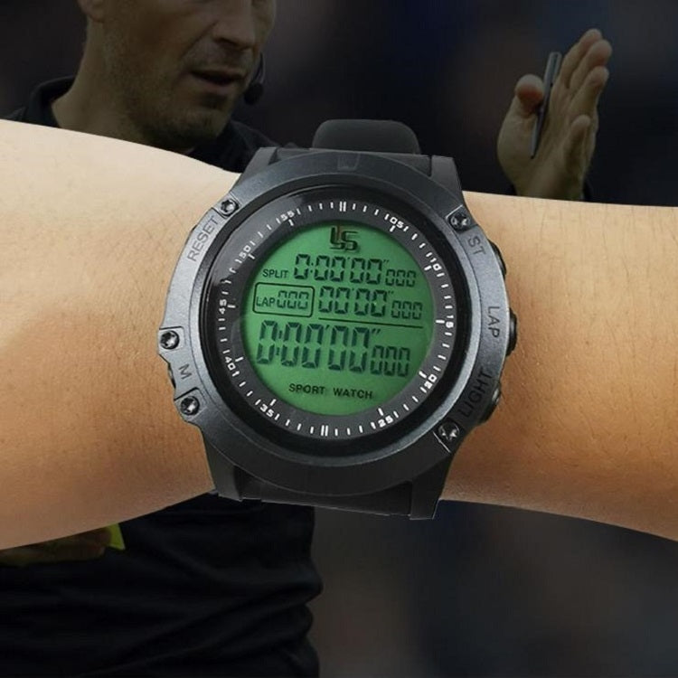 Digital sports stopwatch on wrist with black strap and green illuminated LCD timer display.