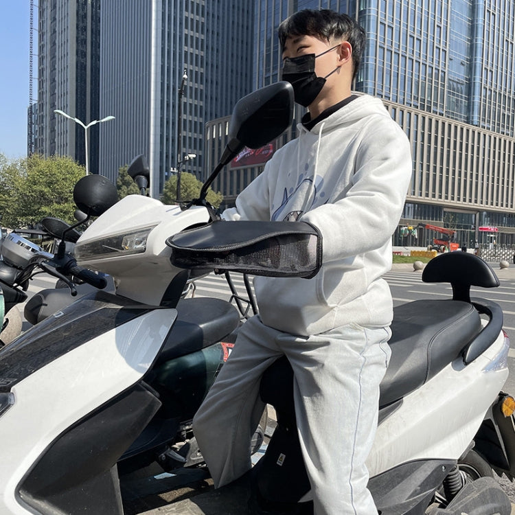 Person wearing face mask holding an e-bike handlebar with black sun glove installed.