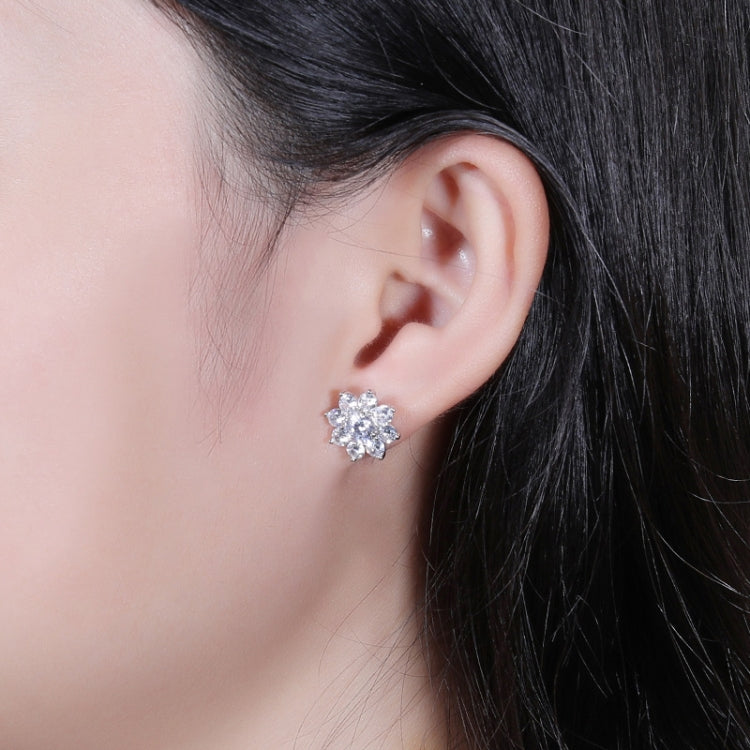 Silver flower stud earrings worn on ear, round center with petal stones