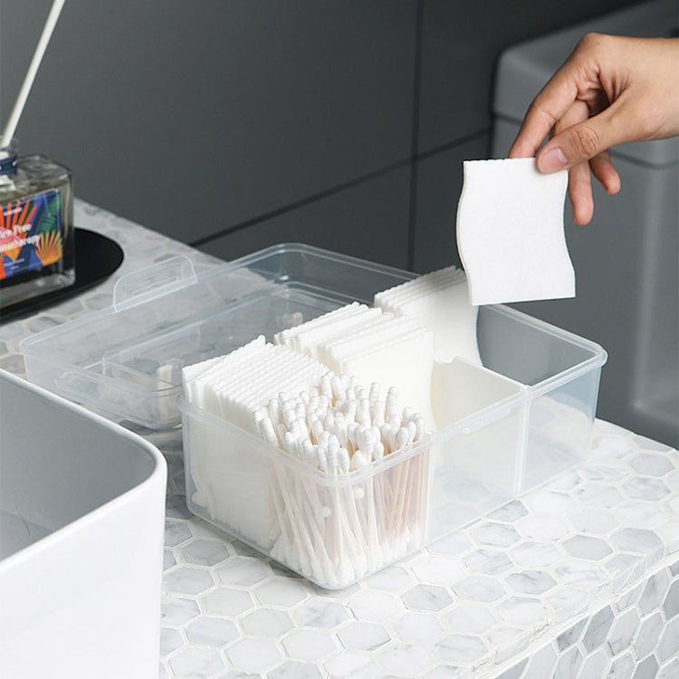 Transparent compartment medicine box holding white cotton swabs and small items
