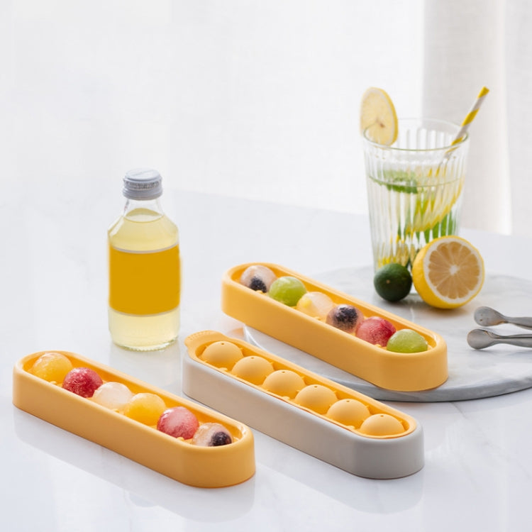 Set of silicone ice cube trays: yellow and gray molds on table with fruit mix