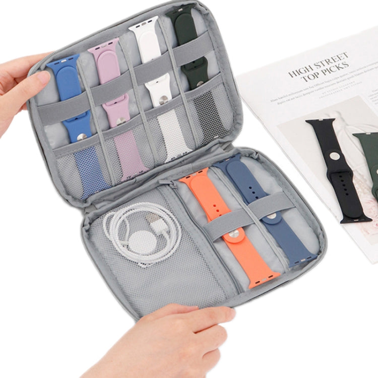 Gray open organizer bag with multiple watch straps and cable compartments