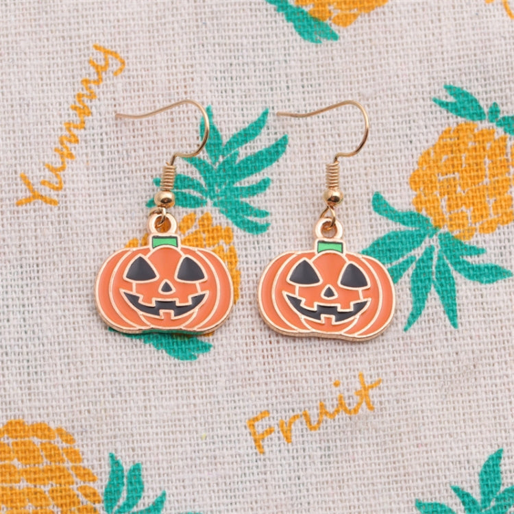 Pair of orange pumpkin jack-o’-lantern earrings with green-top caps on gold hooks