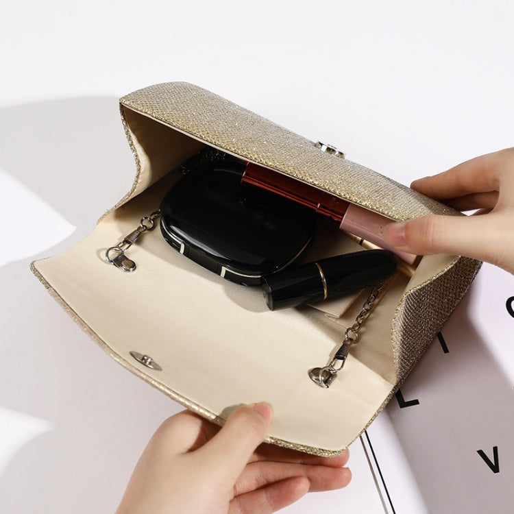 Gold square evening bag opened to show interior and chain strap hardware