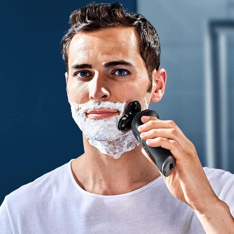 Electric shaver blade head in use on a man's chin