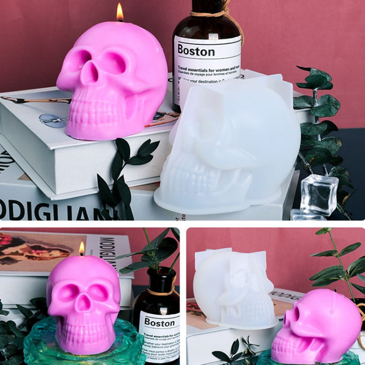 Skull silicone candle moulds in white and pink, with a bottle and flame nearby.