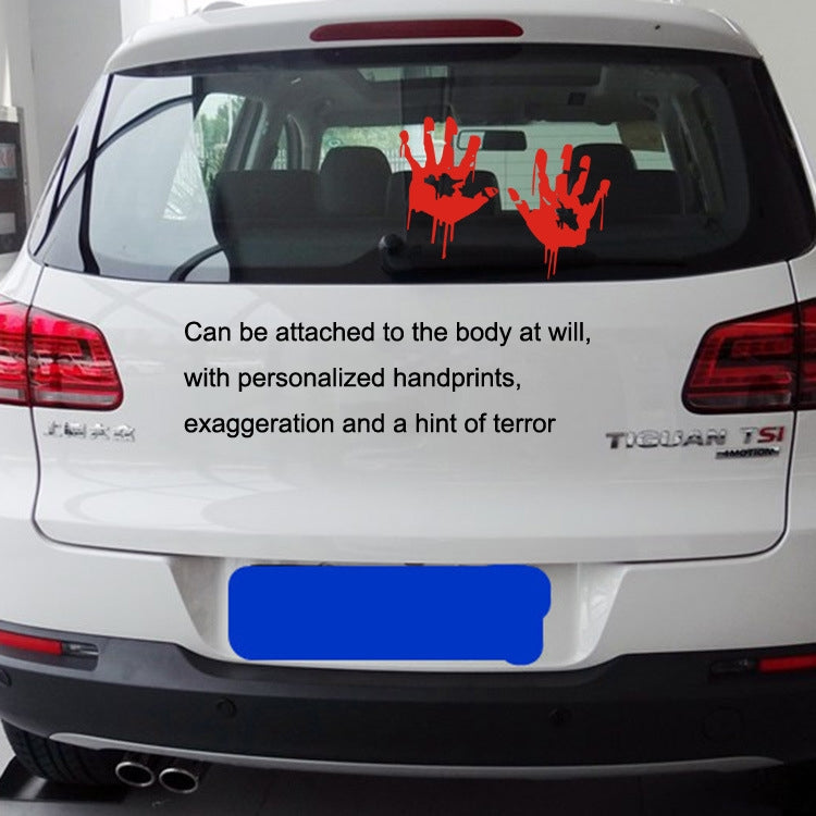 Reflective red blood handprint decals on a car rear window