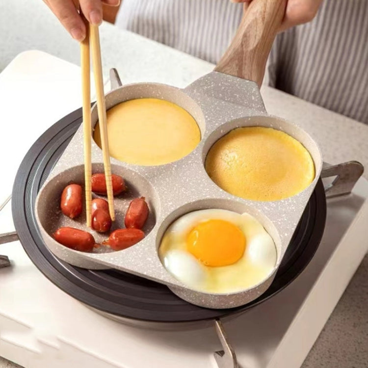 Four-hole egg frying pan with sunny-side-up eggs and sliced peppers in wells