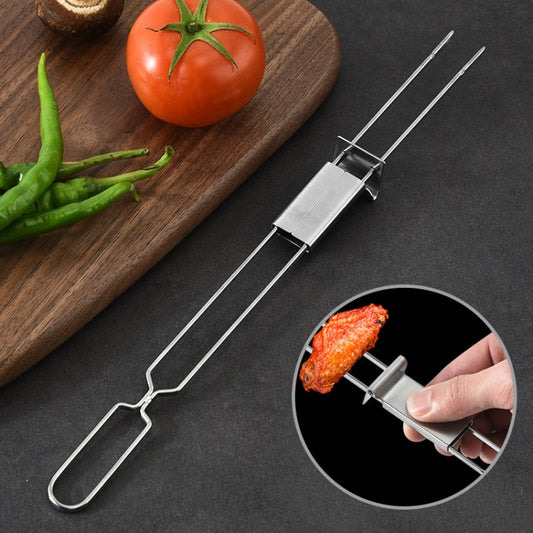 Stainless steel double-head BBQ fork with prongs, shown with grilled food and vegetables