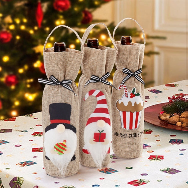 Three jute-style Christmas bottle tote covers with ribbon bows and festive front designs