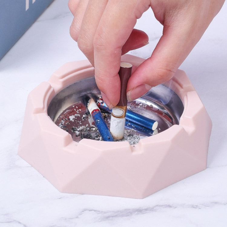 Pink ashtray open with cigarettes inside and hand placing a cigarette