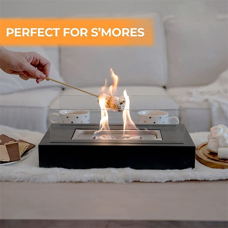 Tabletop metal alcohol fireplace burning with clear glass panels on a tabletop