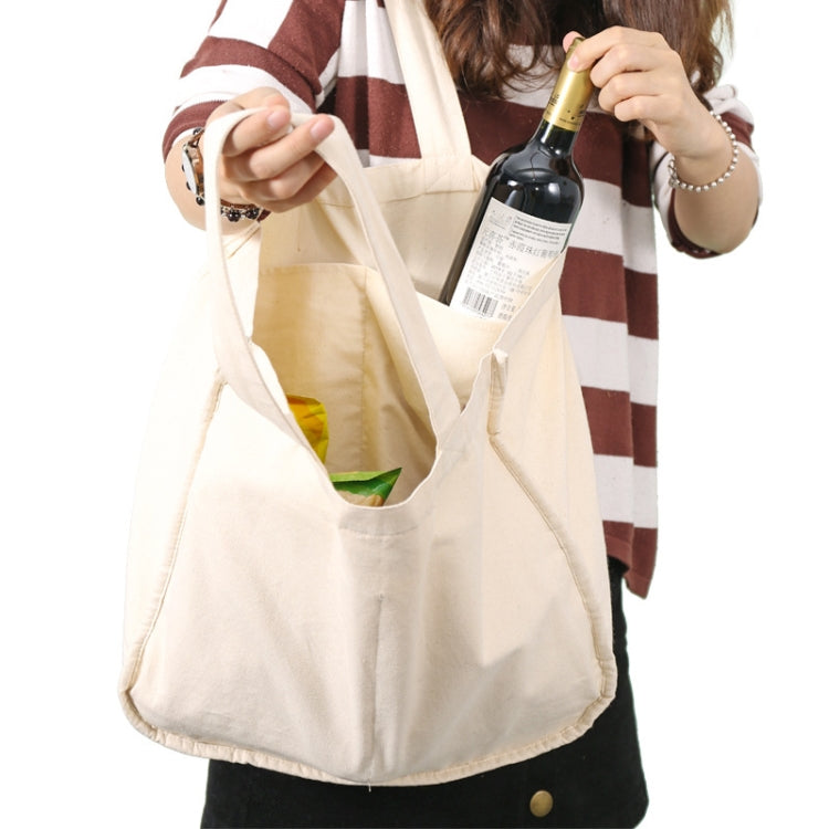 Cream compartment shopping tote with long handles, worn over shoulder