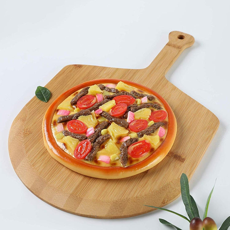 Bamboo paddle serving tray holding a small topped pizza, natural wood color