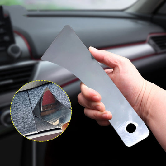 Stainless steel car panel trim removal tool with circular hole, held in hand