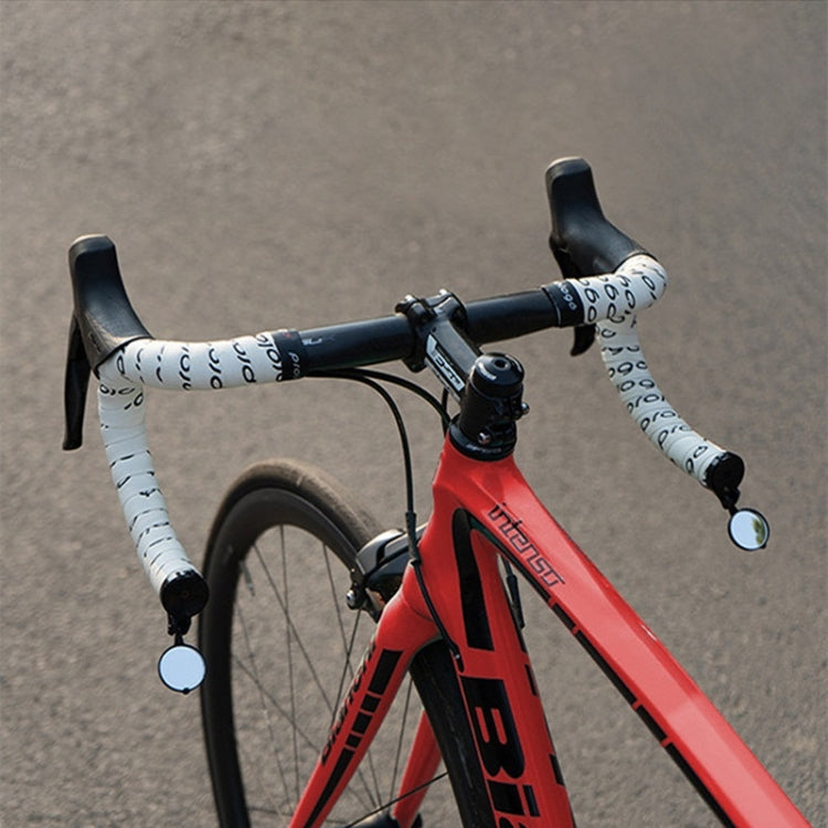 Bicycle handlebar rearview mirror mounted on a bike with white grips and folding round head
